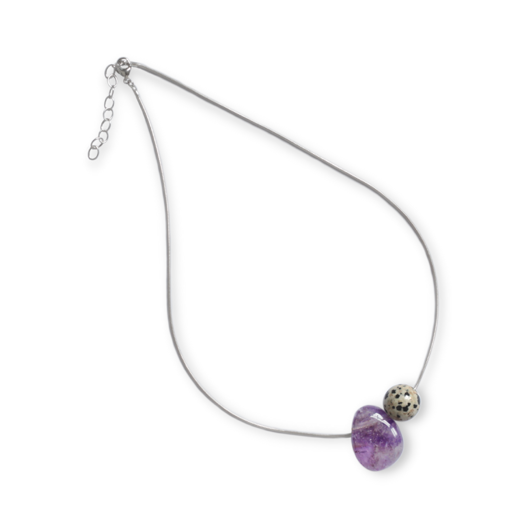 Asymmetrical Semiprecious Gemstone Crystal Pendant Neklace with an Asymmetrical Lilac Amethyst Pendant and Round Beige and Black Dalmatian Jasper Bead on a Solid Sterling Silver Snake Chain with a Sterling Silver Clasp and Extension Chain on a Blank Background