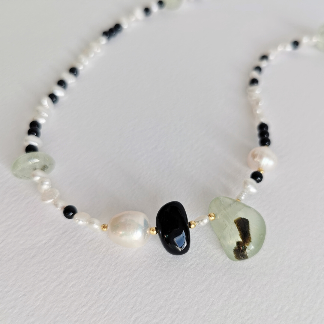 Asymmetrical Semiprecious Gemstone Bead Necklace with Green Prehnite, Black Onyx, White Freshwater Pearls, Gold Vermeil Hardware and Extension Chain, Closeup on a White Background