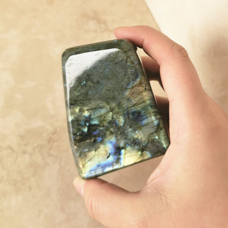 high quality polished multicoloured Labradorite statue held by hand