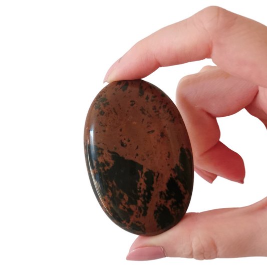 oval polished clay red and black Mahogany Obsidian palm crystal held by hand